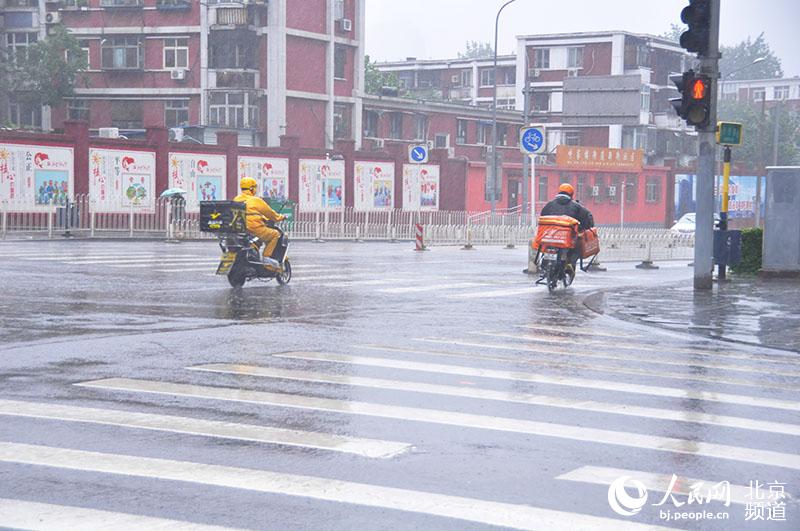 组图:北京大雨外卖订单暴涨 送餐小哥风雨无阻