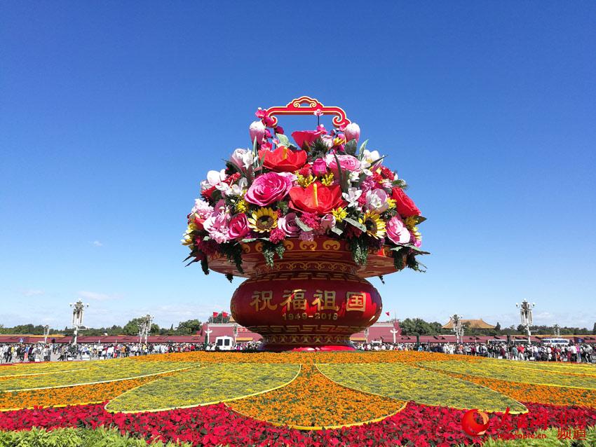 今天上午，天安门广场中心布置的“祝福祖国”巨型花篮组装完成，展现在游客面前。人民网尹星云 摄