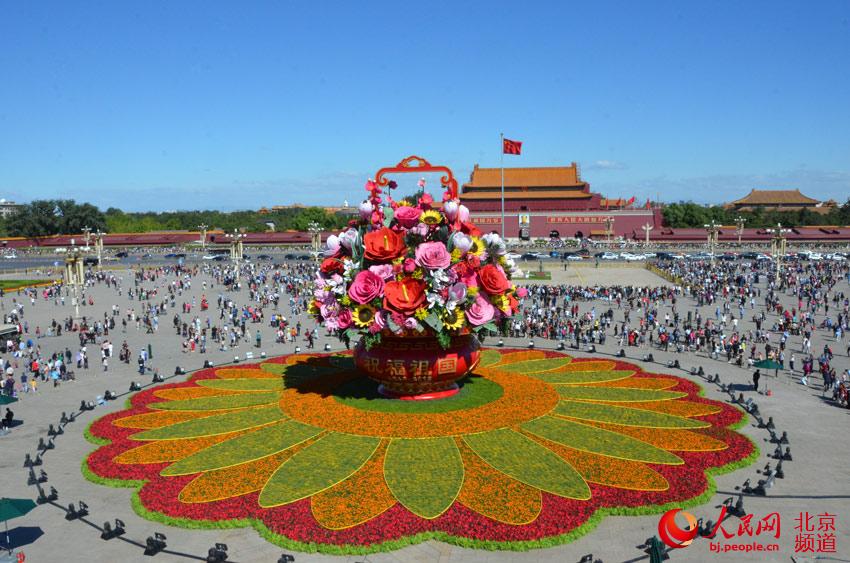 今天上午，天安门广场中心布置的“祝福祖国”巨型花篮组装完成，展现在游客面前。人民网尹星云 摄