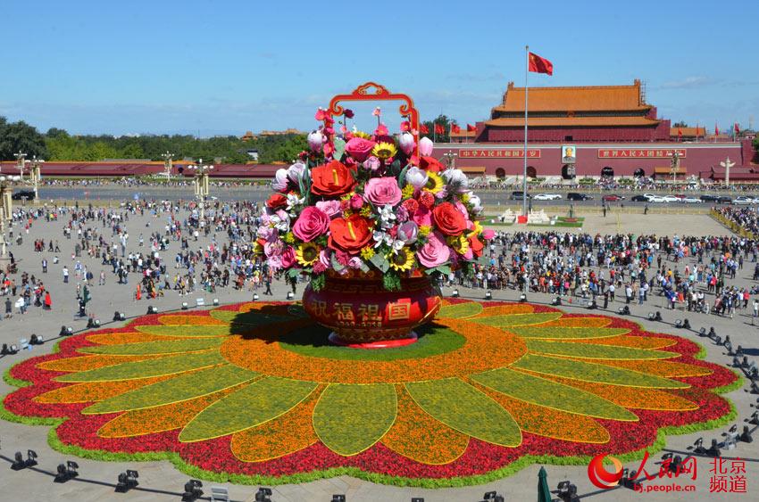 今天上午，天安门广场中心布置的“祝福祖国”巨型花篮组装完成，展现在游客面前。人民网尹星云 摄