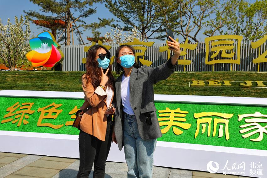 游人在北京世園公園門口自拍。人民網尹星雲 攝