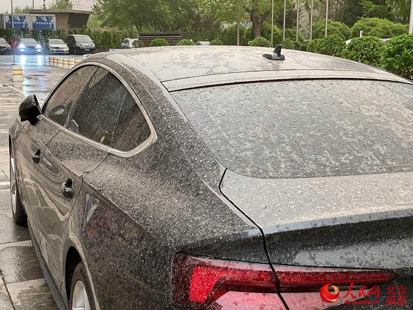 伴著一同而至的短時降雨及大風，停在路邊的汽車都被裹上了一層泥沙。人民網 尹星雲攝