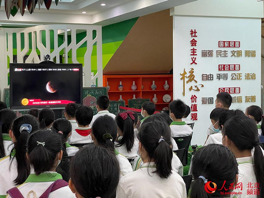 學生們通過電視實時畫面觀看月全食的過程。人民網 尹星雲攝