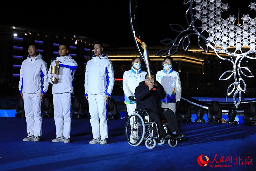 延慶殘疾人代表孟玉林手持火炬向四周展示。人民網 尹星雲攝