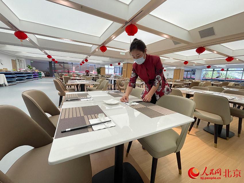 延慶奧林匹克園區內，餐飲服務人員在整理餐具。人民網 尹星雲攝