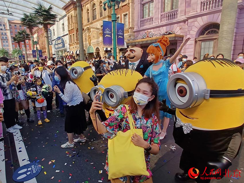 9月20日，一名游客在北京環球影城一周年慶祝活動上和“小黃人”合影。人民網記者 鮑聰穎攝