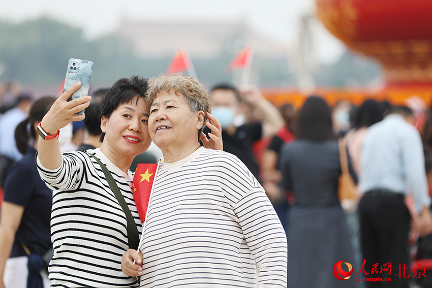 游客在天安门广场拍照留念。人民网 尹星云摄