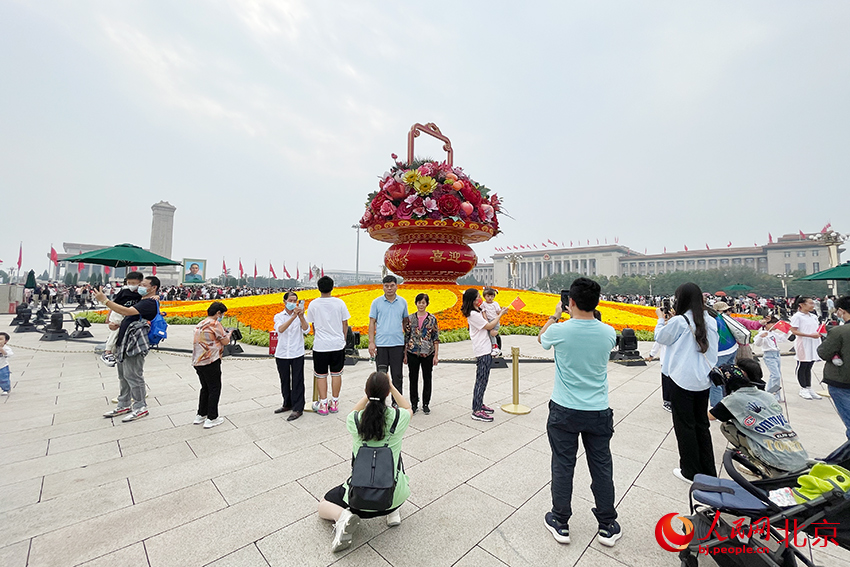 游客在“祝福祖国”巨型花果篮前合影留念。人民网 尹星云摄