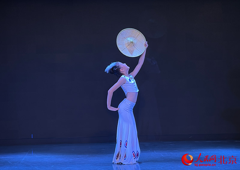 来自西城区蒲公英青少年志愿团队的吕首坤表演舞蹈《孔雀月影》。