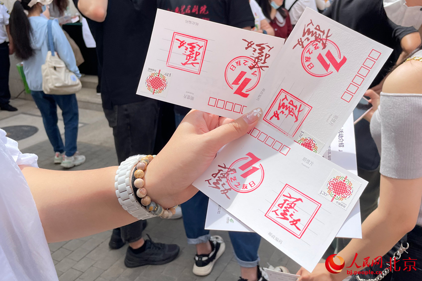 观众在明信片上集盖人艺院庆徽章。人民网记者 尹星云摄