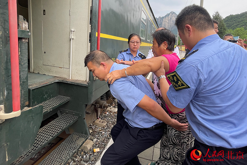 列车员帮助行动不便群众上车。人民网记者 尹星云摄