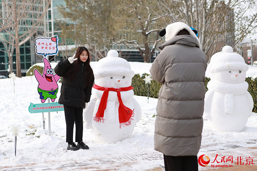 北京金融街街心花园附近，市民与雪人合影。郭斌摄