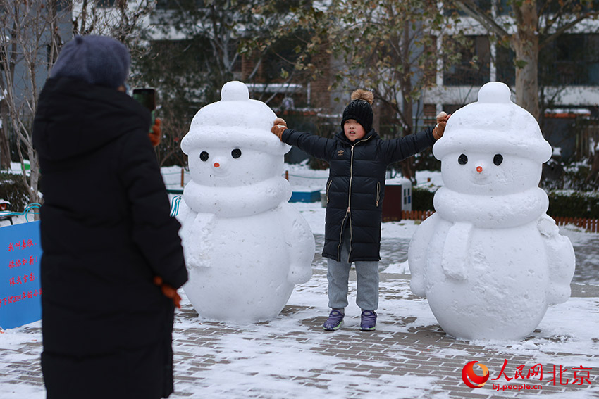 孩子与雪人合影。郭斌摄