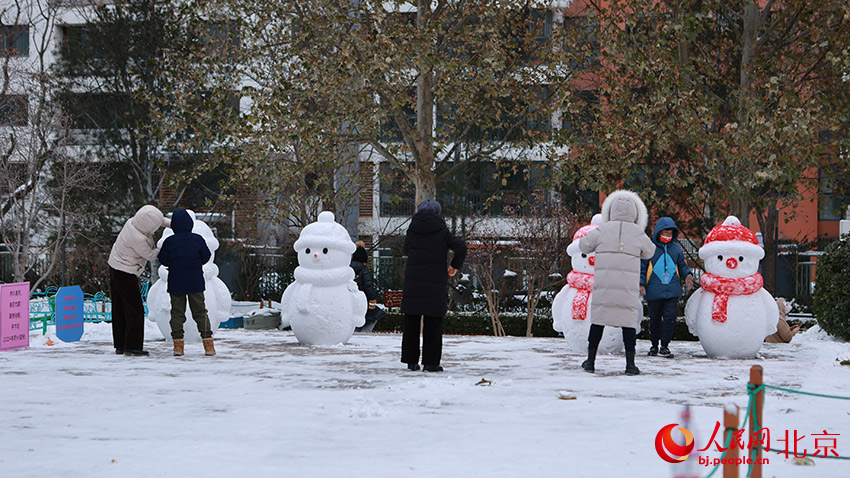 居民与雪人合影。郭斌摄