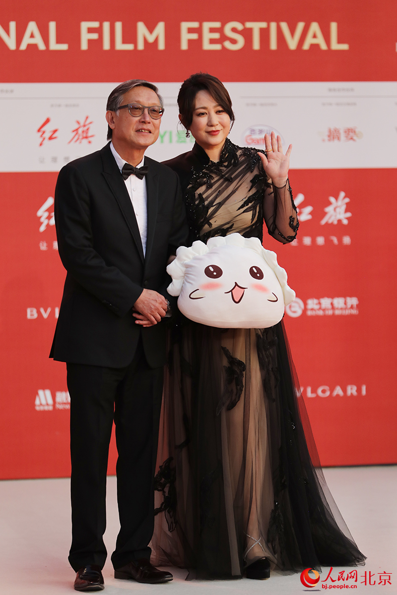 《水餃皇后》導演劉偉強和演員馬麗拿著餃子玩偶亮相開幕式紅毯。人民網記者 尹星雲攝