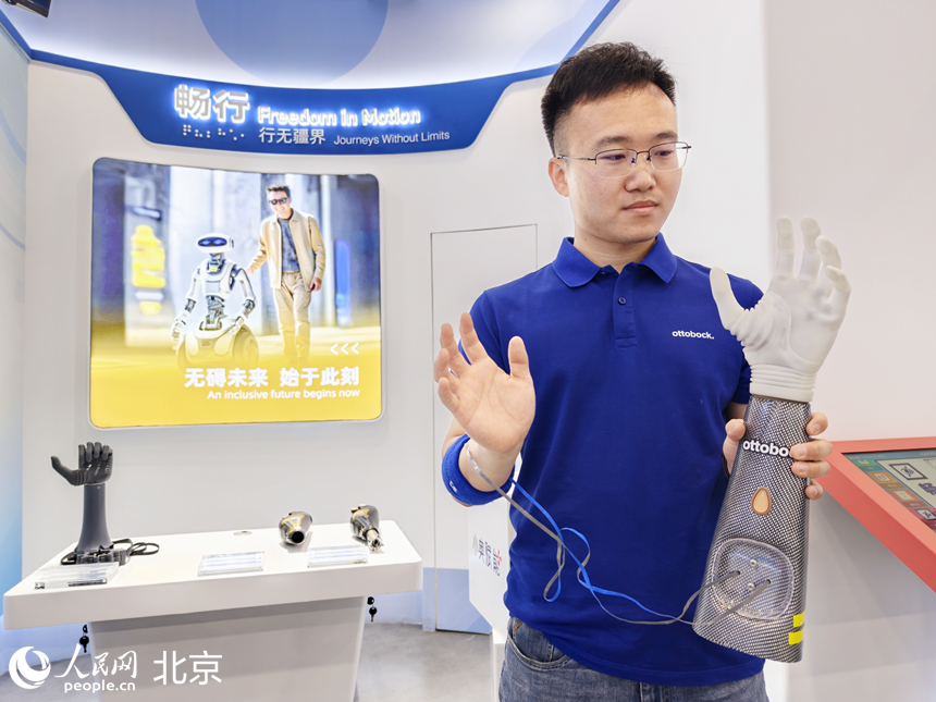 工作人员展示科技助残产品。 人民网记者 李博摄