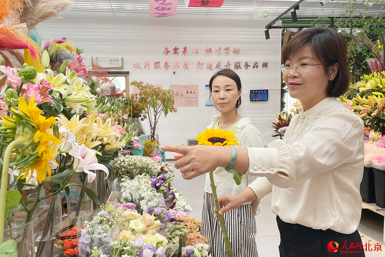 北京花鄉花木集團董事長林巧玲和花商交流工作。人民網記者 尹星雲攝