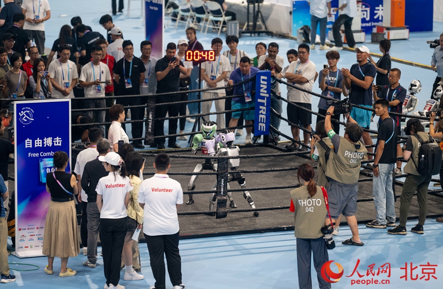 人形机器人正在进行自由搏击比赛。人民网记者 翁奇羽摄