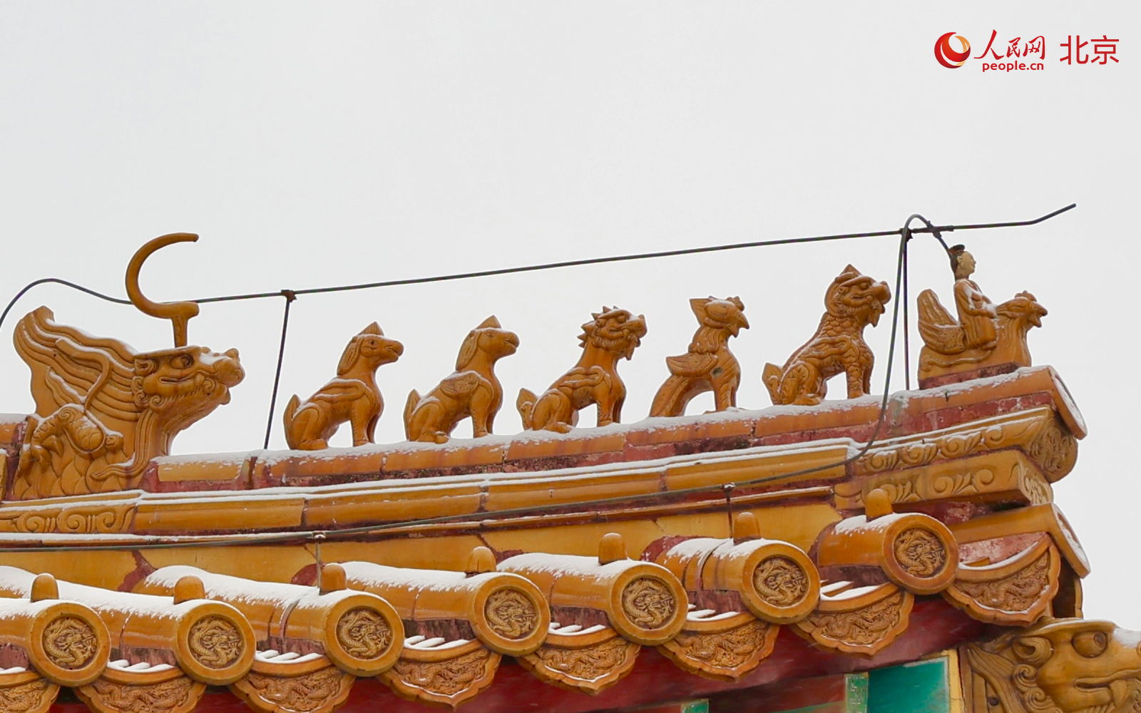 降雪当天，故宫博物院内红墙金瓦在雪色映衬下更显沉静。人民网记者 李世奇摄