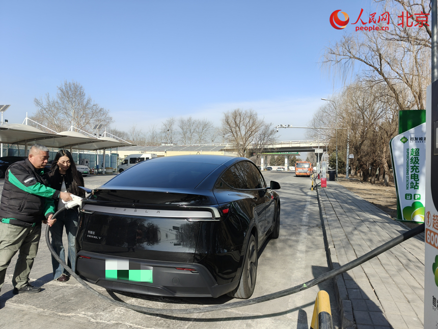 服務區工作人員為車主提供充電服務。人民網記者 李博攝